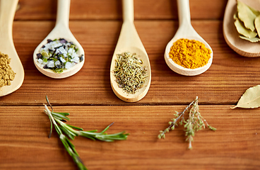 Image showing spoons with spices and salt on wooden table