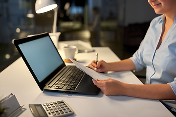 Image showing businesswoman with papers working at night office