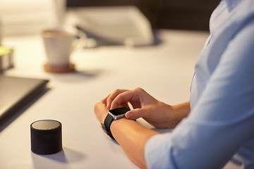 Image showing woman with smart watch and speaker at night office