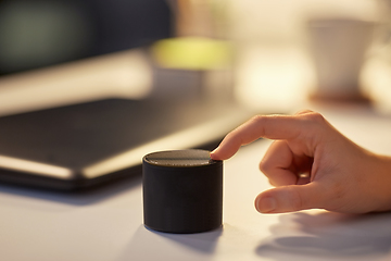 Image showing close up of hand with smart speaker at office