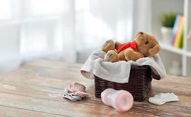 Image showing teddy bear toy in basket with baby things on table