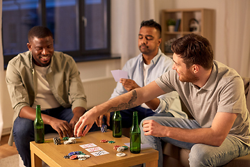 Image showing smiling male friends playing cards at home