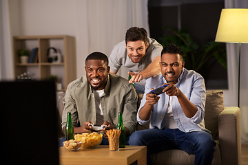 Image showing happy friends playing video games at home at night