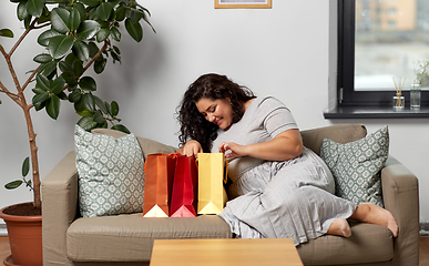 Image showing happy young woman with shopping bags at home