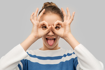 Image showing funny teenage girl looking through finger glasses