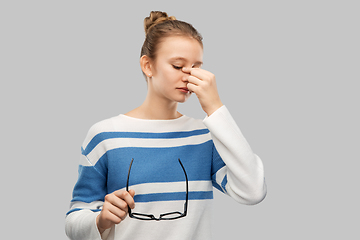 Image showing teenage girl with glasses rubbing nose bridge