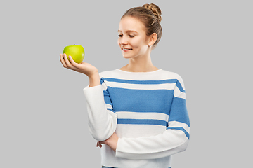 Image showing smiling teenage girl in pullover with green apple