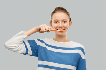 Image showing happy teenage girl brushing teeth with toothbrush