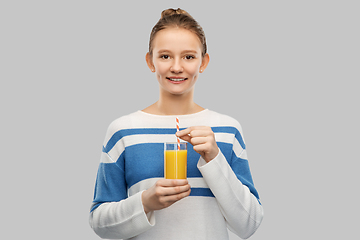 Image showing smiling teenage girl holding glass of orange juice