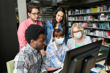 Image showing students in medical masks with computer at library