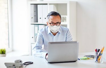 Image showing businessman in medical mask with laptop at office