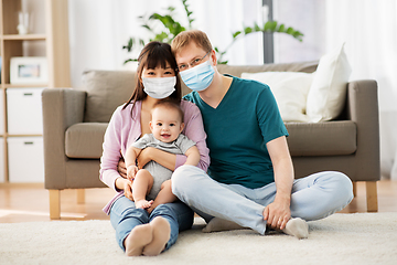 Image showing family with baby in medical masks at home