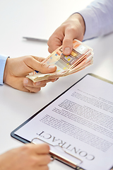 Image showing close up of hands with euro money and contract