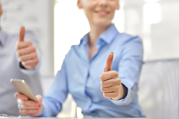 Image showing portrait of smiling young woman showing thumbs up