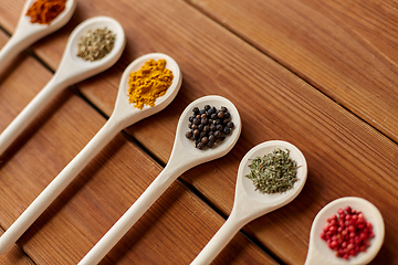 Image showing spoons with different spices on wooden table