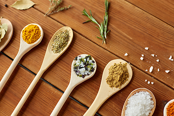 Image showing spoons with spices and salt on wooden table