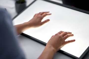Image showing hands on led light tablet at night office