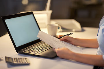 Image showing woman with laptop and papers at night office