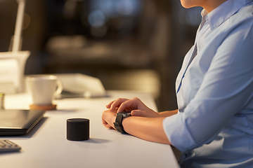 Image showing woman with smart watch and speaker at night office