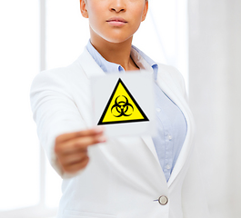 Image showing female doctor holding boihazard caution sign