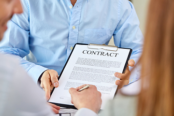 Image showing customer signing contract document at office