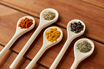 Image showing spoons with different spices on wooden table