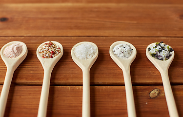 Image showing spoons with salt and spices on wooden table
