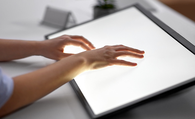 Image showing hands on led light tablet at night office