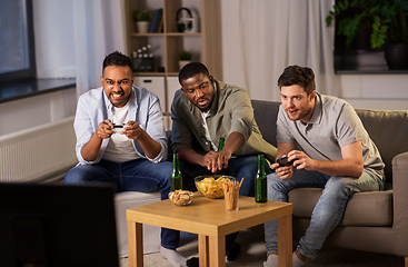 Image showing happy friends playing video games at home at night