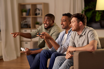 Image showing happy friends playing video games at home at night
