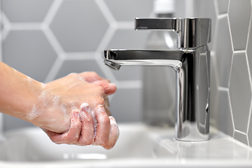 Image showing close up of woman washing hands with liquid soap