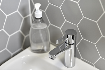 Image showing close up of water tap with liquid soap on sink