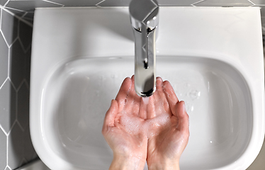 Image showing close up of woman washing hands with liquid soap