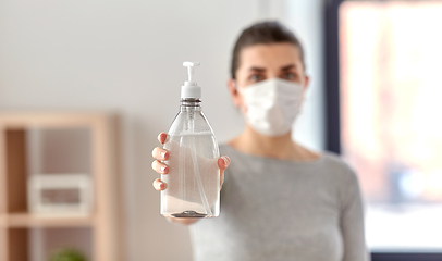 Image showing close up of woman in mask holding hand sanitizer