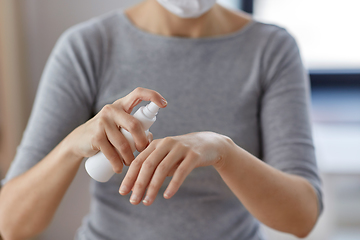 Image showing close up of woman spraying hand sanitizer