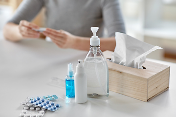 Image showing medicines and sick woman with thermometer at home