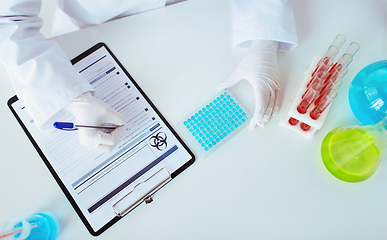 Image showing scientist with tests writing report of biohazard