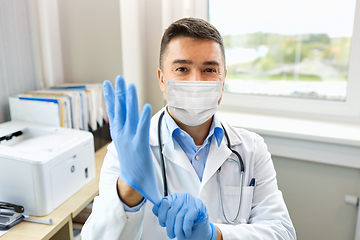 Image showing doctor in medical mask wearing gloves at hospital