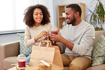 Image showing happy couple with takeaway food and drinks at home