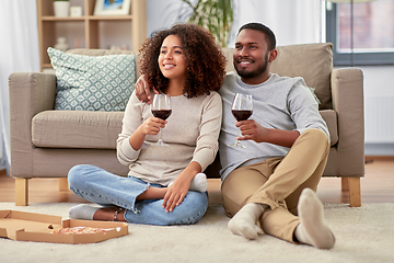 Image showing happy couple with wine and takeaway pizza at home