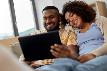 Image showing happy couple with tablet pc computer at new home