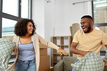 Image showing happy couple having pillow fight at new home