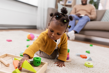 Image showing african baby girl playing with toy blocks at home