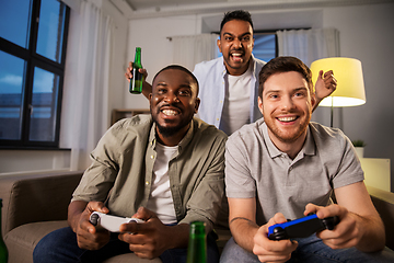 Image showing happy friends playing video games at home at night