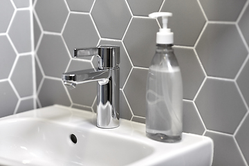 Image showing close up of water tap with liquid soap on sink