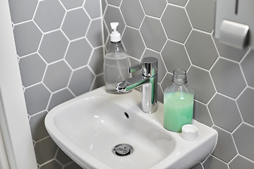 Image showing close up of water tap with liquid soap on sink