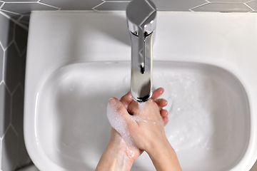 Image showing close up of woman washing hands with liquid soap