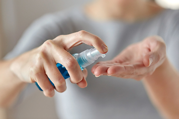 Image showing close up of woman spraying hand sanitizer