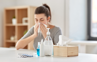 Image showing medicines and sick woman blowing nose to wipe