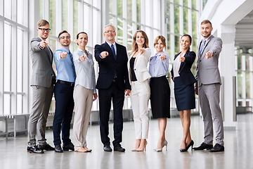 Image showing business people pointing to camera at office